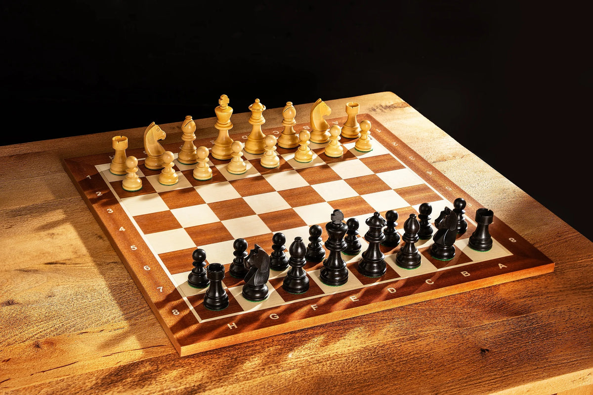 Échiquier en acajou et pièces noires posés sur une table en bois