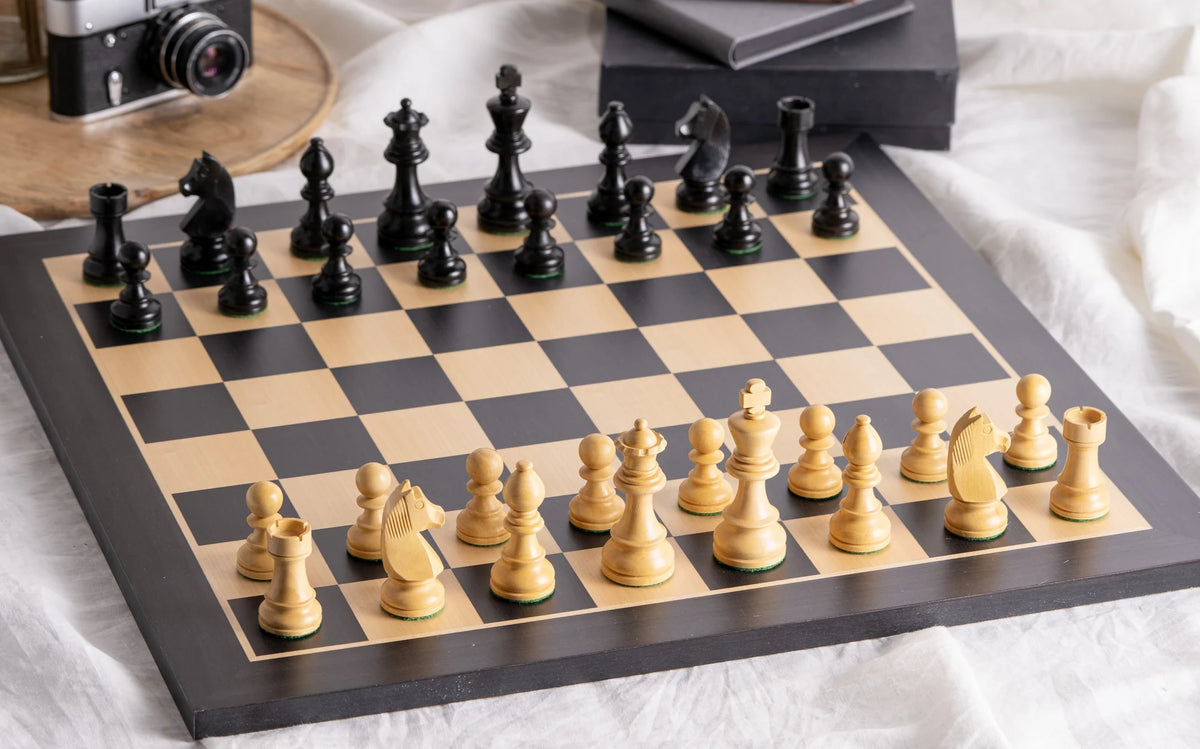 Échiquier Grand Classique en bois noir et ses pièces dans un salon lumineux