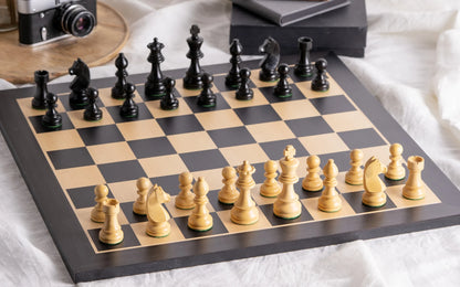 Échiquier Grand Classique en bois noir et ses pièces dans un salon lumineux