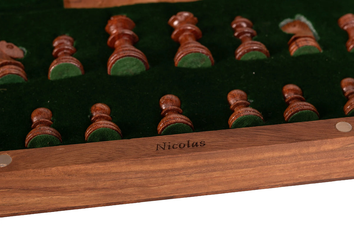 Prénom Nicolas gravé sur le bord intérieur d’un coffret d’échecs en bois